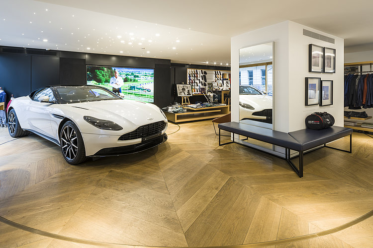 Lounge area with a white sports car on the presentation surface